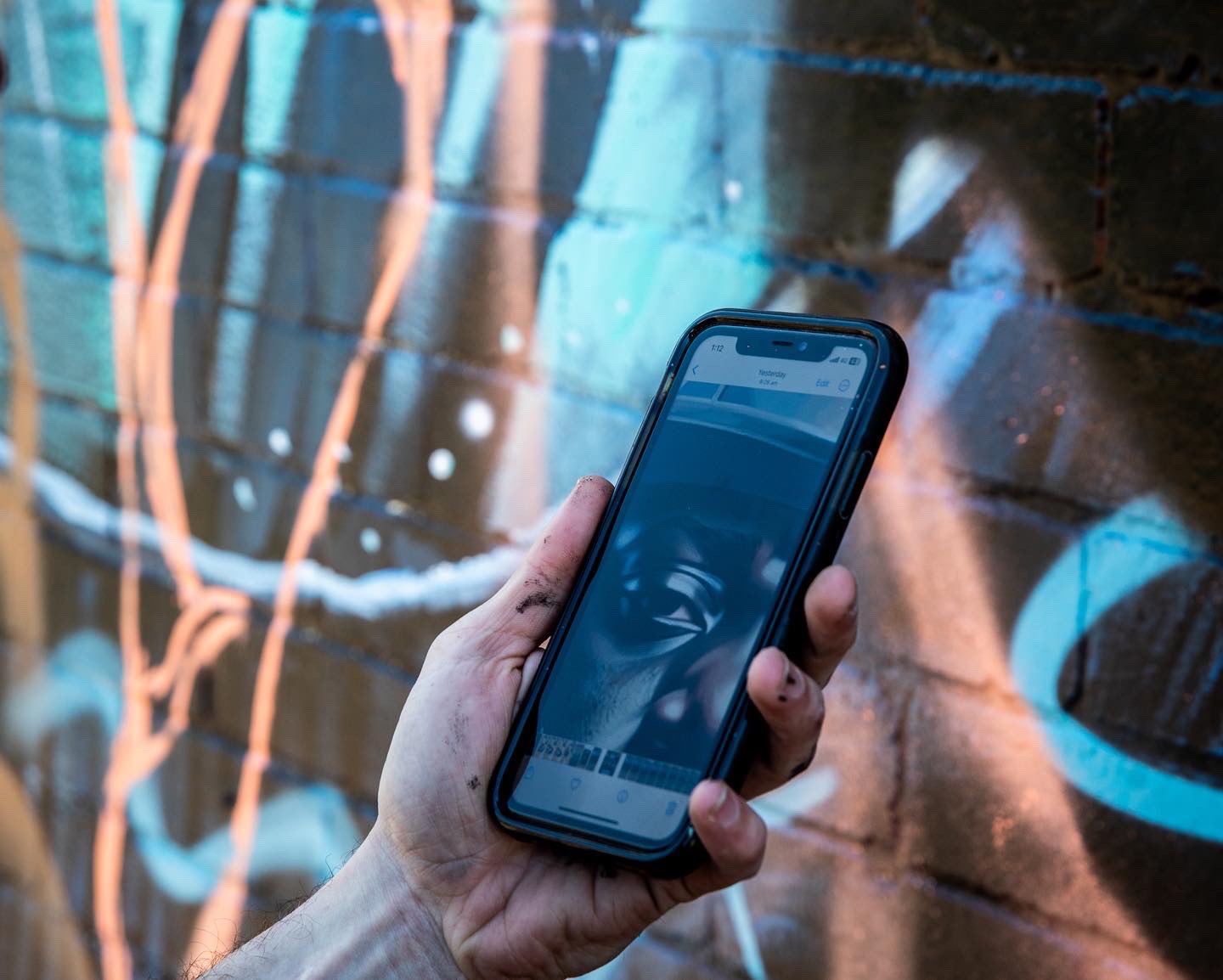 Reference photo on phone in front of mural