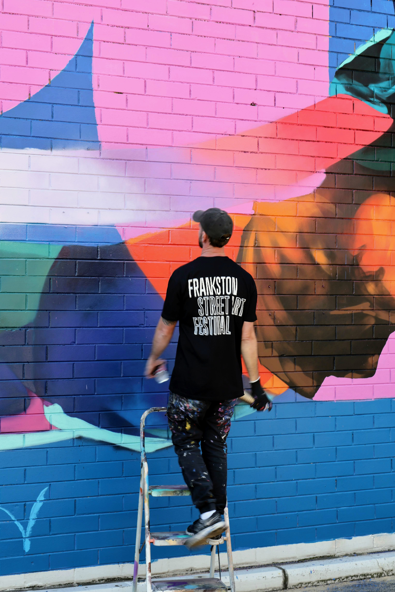 Artist painting the PushPull mural on site