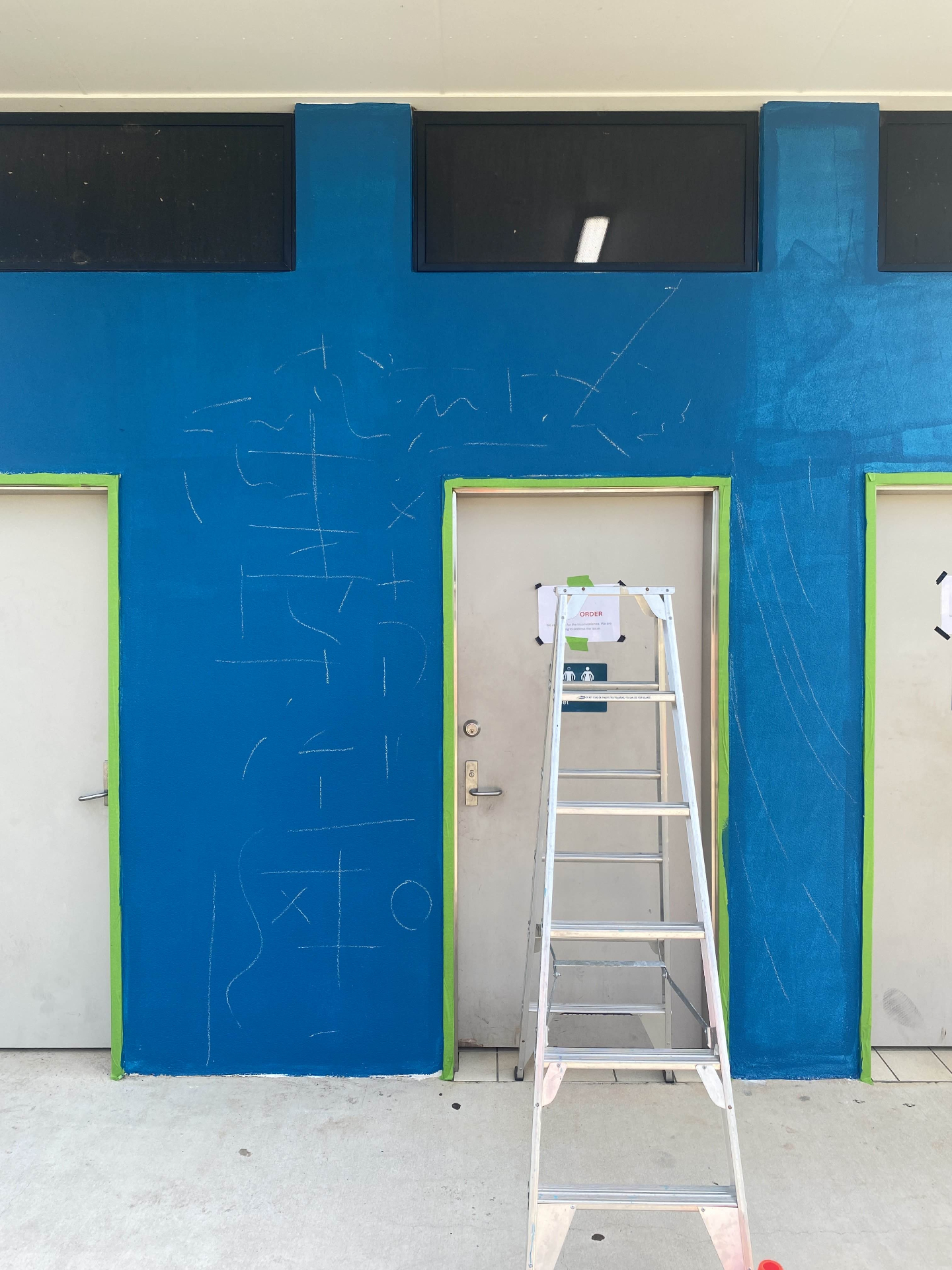 Chalk sketch layout on the freshly painted blue wall