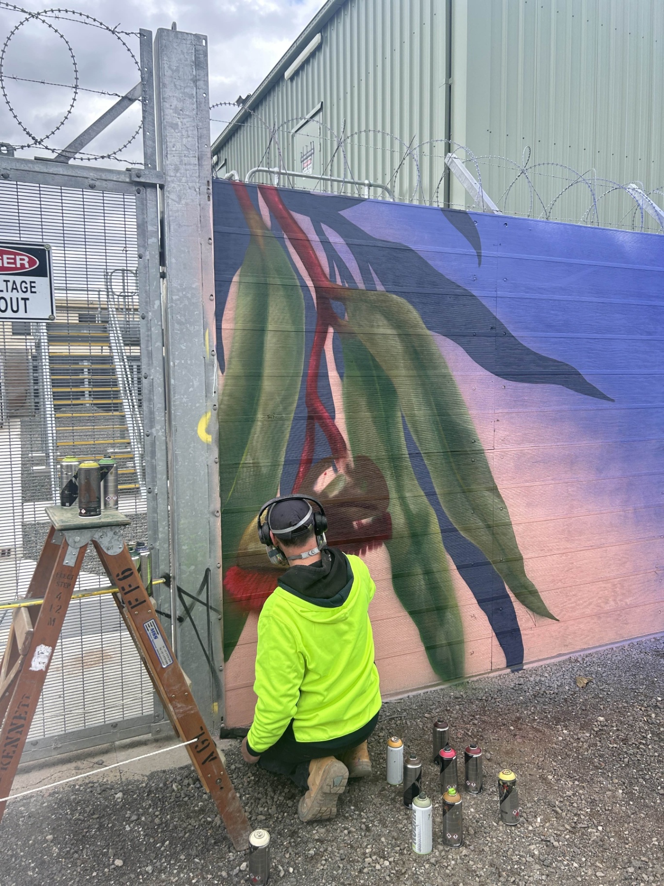 Artist in progress on eucalyptus leaves mural panel