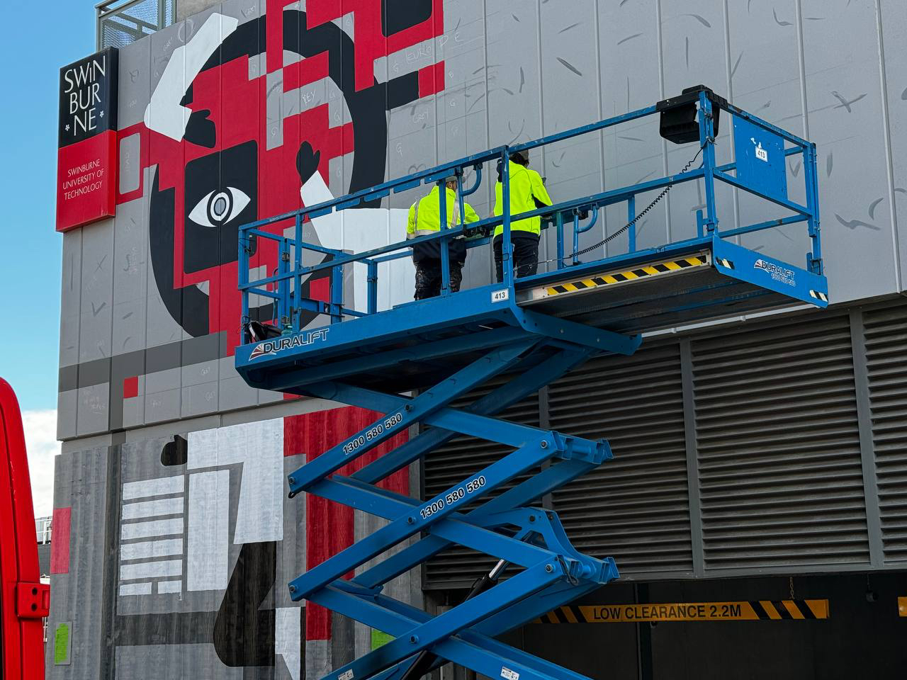 Swinburne mural, close-up on scissor lift