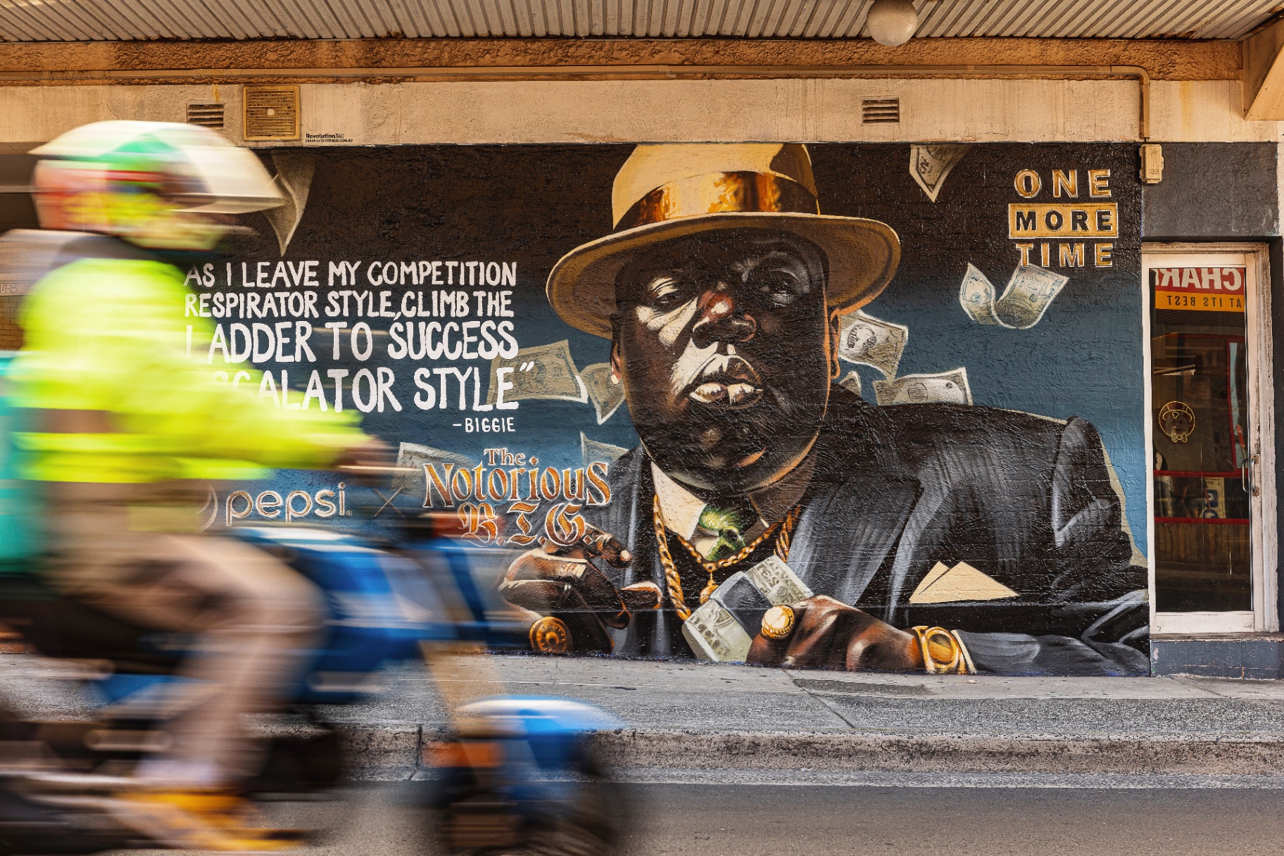 One More Time mural with cyclists passing