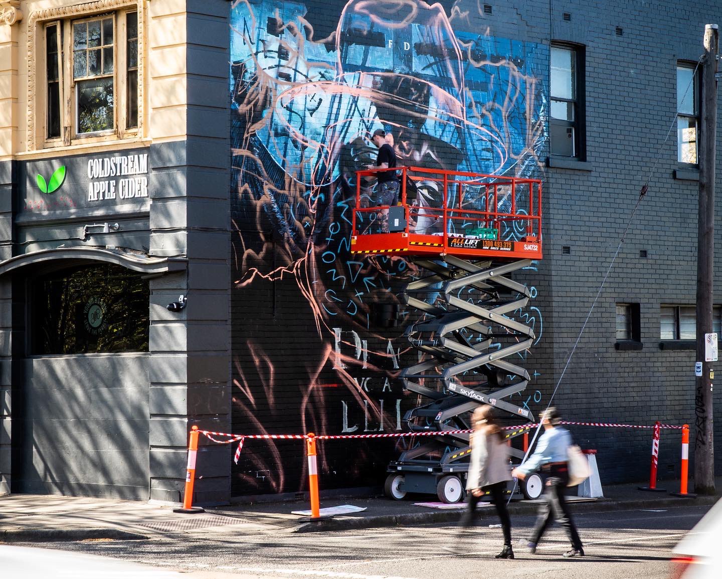 Mural in progress on scissor lift
